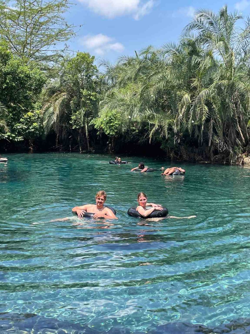 Two travellers floating on inner tubes in the turquoise Kikuletwa spring